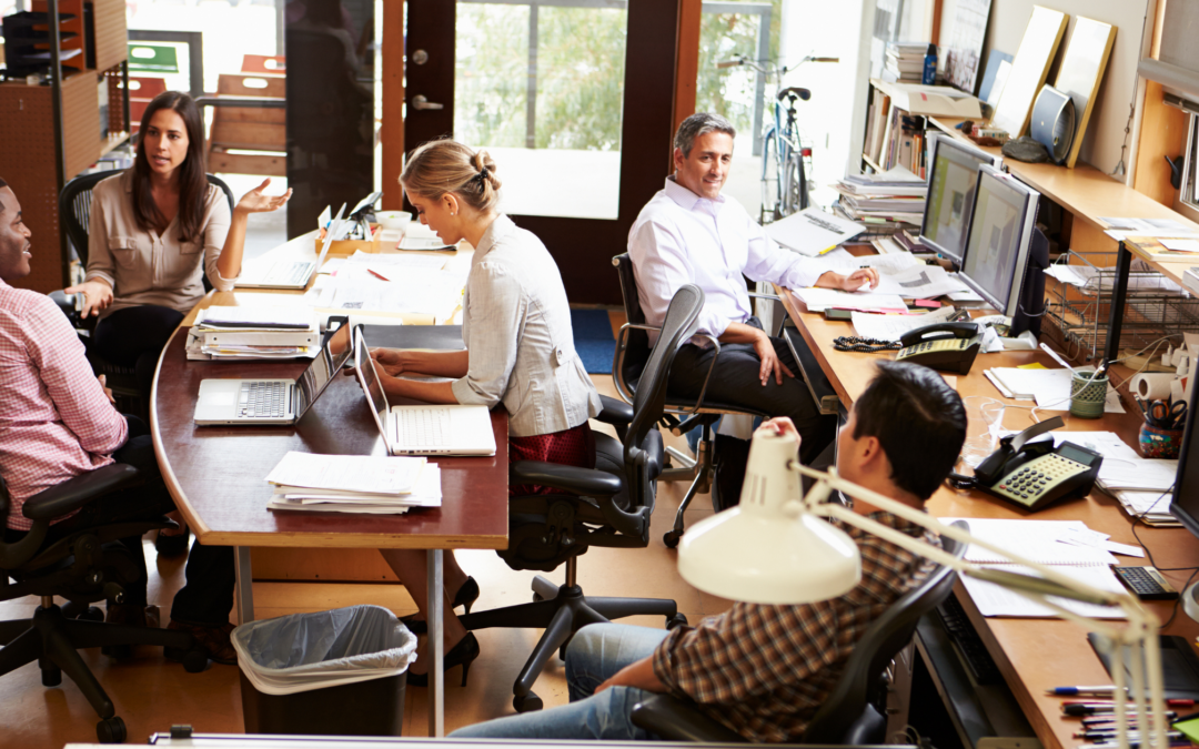 Business Insurance Plan - a group of employees sitting in office having a conversation.